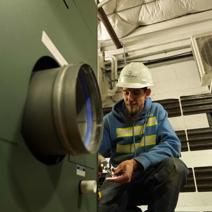Performance Mechanical Group’s technician working on commercial piping.